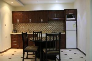 a kitchen with a table and chairs and a refrigerator at Dorar Darea Hotel Apartments- Al Malqa 2 in Riyadh