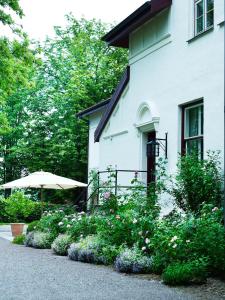 a white house with an umbrella and some flowers at Hotel Frederiksminde in Præstø