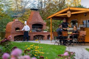 un grupo de personas sentadas en una mesa frente a un horno de ladrillo en Mercure Hotel München Süd Messe, en Múnich