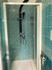 y baño con ducha y azulejos azules. en Good Night Moon B&B, en Crotone 33 fotos más