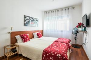 ポルトにあるApartamento À Francos Gyn Loversのベッドルーム1室(大型ベッド1台、赤い枕付)