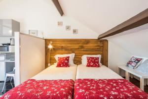 1 dormitorio con 1 cama con almohadas rojas en Apartamento À Francos Attic, en Oporto