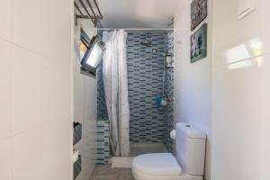 a white bathroom with a toilet and a shower at Apartamento Garden Avenue in Porto