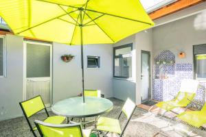 a table and chairs with a yellow umbrella on a patio at Apartamento Garden Avenue in Porto +22 photos