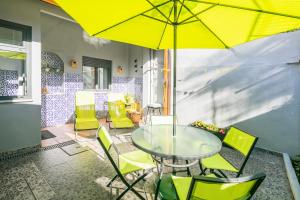 a table and chairs with a yellow umbrella on a patio at Apartamento Garden Avenue in Porto