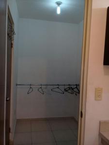 einen Schrank mit Kleiderbügeln an einer weißen Wand in der Unterkunft Consulado Suites in Monterrey