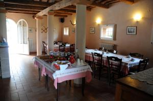 un restaurante con mesas y sillas con comida. en Agriturismo e Cantina La Sabbiona, en Faenza