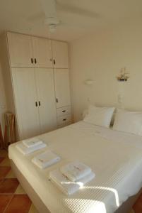 1 dormitorio con 1 cama blanca y 2 toallas en Birds Bay, en Petra
