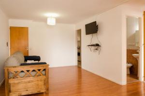 uma sala de estar com televisão numa parede branca em Apartamento Obispo Trejo IV by Lofty em Córdoba