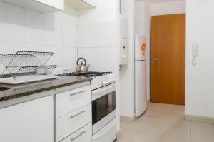 cocina blanca con fogones y fregadero en Apartamento Obispo Trejo IV by Lofty en Córdoba