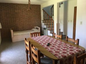 a dining room with a table and chairs and a brick wall at Residencial del Golf in Alta Gracia