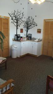 a kitchen with white cabinets and two trees on the wall at Western Inn Motel & RV Park in Fairplay