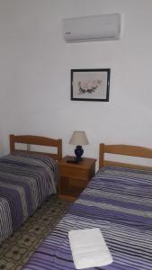 a hotel room with two beds and a lamp on a table at Edificio Sagasti in Piriápolis