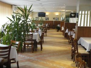Diana 3 Hotel في صوفيا: غرفة طعام بها طاولات وكراسي ونباتات