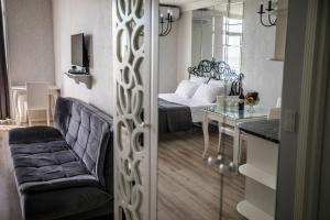 a room with a bed and a chair and a table at Tina's Apartments with Panoramic Sea view in Batumi