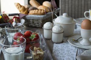 een tafel met glazen melk, aardbeien en brood bij B&B de Rijcke Rust in Rijkevorsel