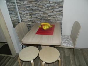 a wooden table with two chairs and a bowl of fruit at Apartment Sofi Yeti in Kopaonik