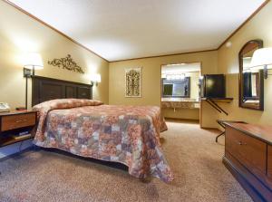 Habitación de hotel con cama y TV en Interstate Inn en Roland