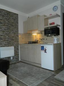 a kitchen with a white refrigerator and a brick wall at Apartment Sofi Yeti in Kopaonik