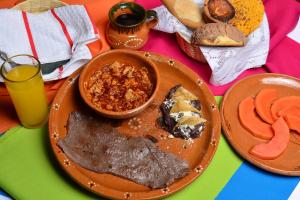 a table with a plate of food and a glass of orange juice at Campestre DAARLU in Huauchinango