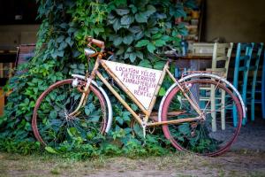 un vélo garé à côté d'un arbre avec un panneau sur celui-ci dans l'établissement Domaine du Bourg Gites, à Gannay-sur-Loire