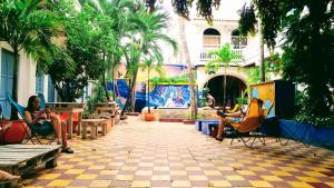 a patio area with tables, chairs, and tables with umbrellas at Media Luna Hostel Cartagena in Cartagena de Indias