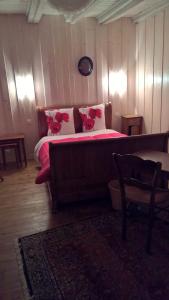 a bedroom with a large bed with pink pillows at Chambre d Hote 1873 in Frasne