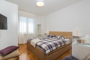 una camera bianca con letto e TV di Apartment Qualich a Plomin (Fianona)