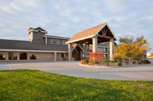 a large house with a gambrel roof at AmericInn by Wyndham Osceola in Osceola