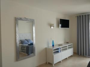 アロナにあるLos Cristianos studio, modern, spacious, pool,WiFiの鏡、ベッド、ドレッサーが備わる客室です。