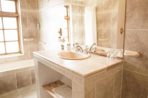 a bathroom with a sink and a tub at Hostería El Pilar in El Chalten