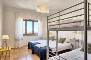 リスボンにあるApolónia 3 Frontal River Viewのベッドルーム1室(二段ベッド2台、窓付)が備わります。
