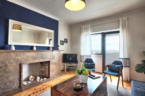 a living room with a fireplace and a tv at Apolónia 3E Five Bedrooms in Lisbon