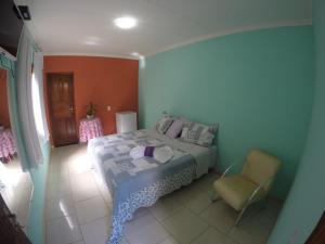 a bedroom with a bed and a chair at Pousada Serraninhos in Santa Leopoldina