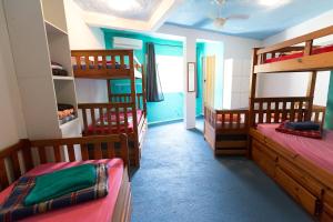 a room with three bunk beds and a room with a hallway at Natural Do Rio Guesthouse in Rio de Janeiro