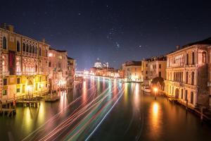 una strada di città di notte con edifici e luci di Silk Road a Venezia