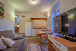 a living room with a couch and a kitchen with a table at Apartments Calma in Cres