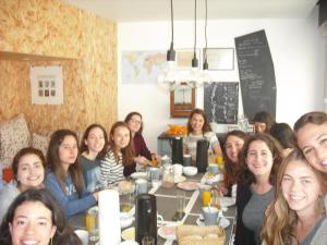 a large group of people sitting around a table at Lab Hostel Nazare in Nazaré