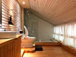 a bathroom with a toilet and a sink and a tub at Zen Box House in Yangshuo