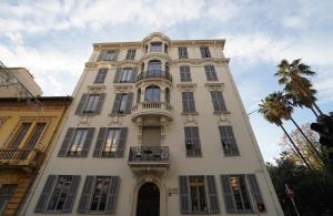a tall white building with windows and a balcony at Carré d'OR! Park view! in Nice