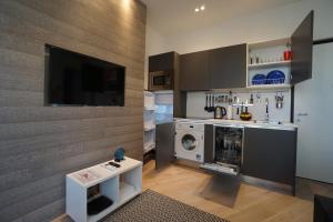 a kitchen with a washing machine and a tv at Carré d'OR! Park view! in Nice