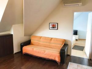 an orange blanket on a bench in a room at Cozy Flat in Villa Near Old Town in Bucharest