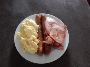 a plate of breakfast food with sausage and mashed potatoes at Cotswold Motor Inn in Toowoomba