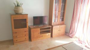 sala de estar con TV y centro de entretenimiento de madera en Relaxing Atico Playa Sardina, en Gáldar