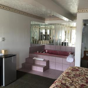 a bathroom with a red tub and a red sink at Valley Motel Pittsburgh in Harmarville