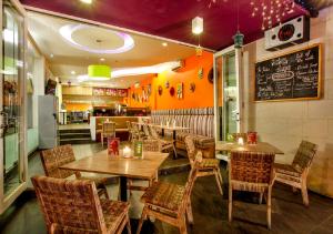 a restaurant with wooden tables and chairs and a chalkboard at Euphoria Hotel in Legian