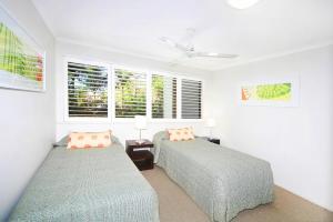 A bed or beds in a room at Noosa Shores Apartment 10