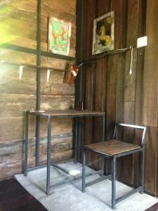 a table and a chair in a room at The Shadow House & Bar in Ko Phayam