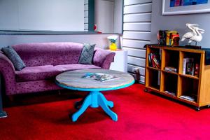 a living room with a purple couch and a table at Bayview Hotel - Batemans Bay in Batemans Bay