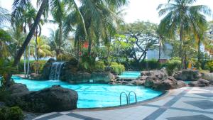 a swimming pool with a waterfall in a resort at Grand Tropic Suites Hotel in Jakarta
